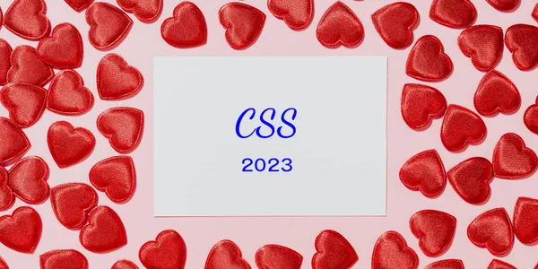 A collection of hearts surround a piece of paper with the text: CSS 2023.
