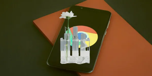 A mobile phone with the Chome logo on the screen lies on a worktop. Above it floats some test tubes with one test tube containing a flower.