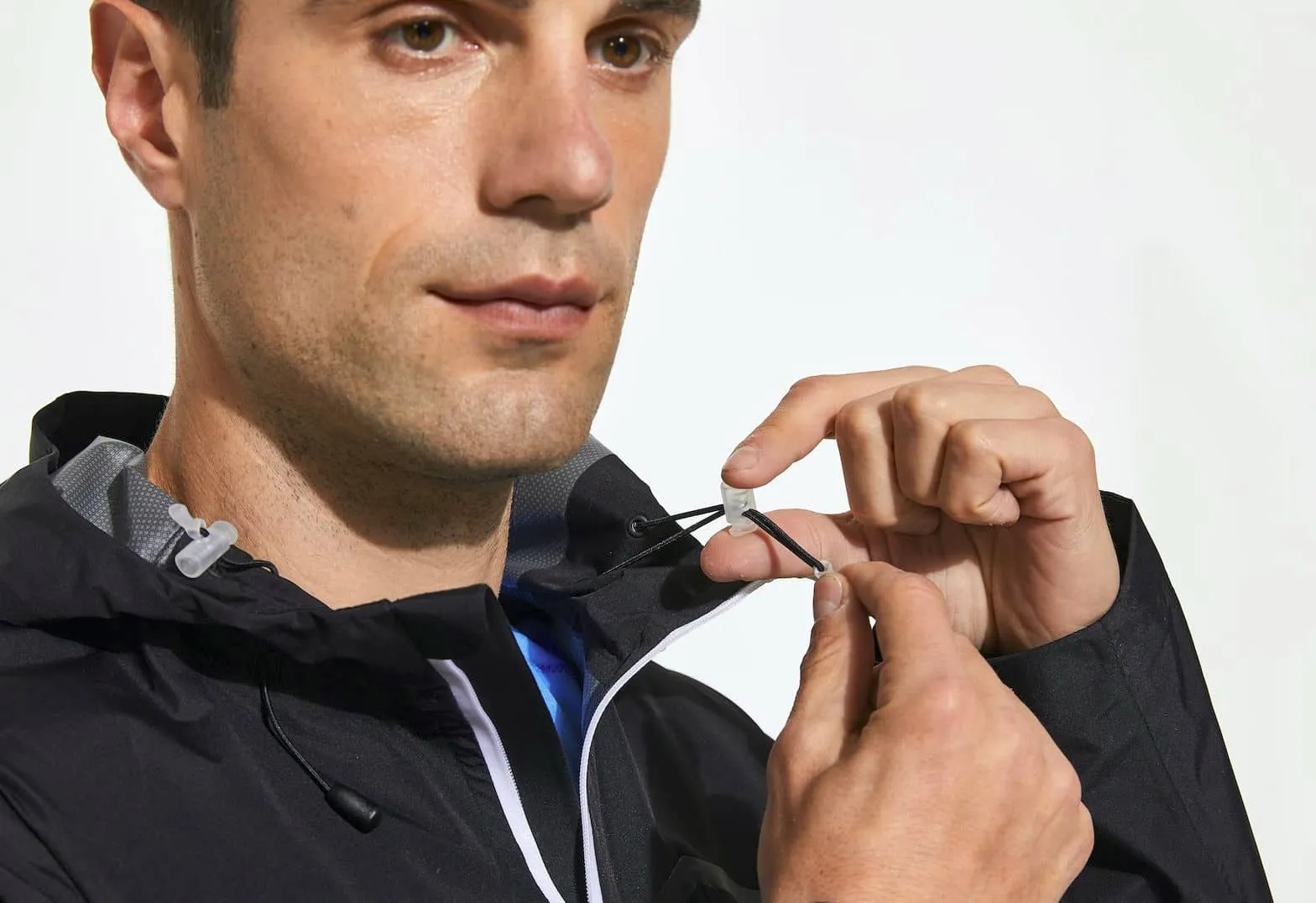 man adjusting his jacket by sliding a toggle. being used in facetious way.